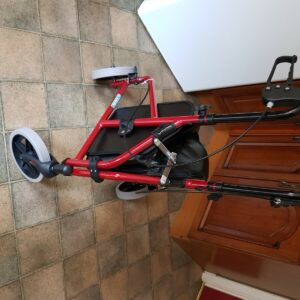 Brand new zimmer frame with three wheels. Red in colour with compartment